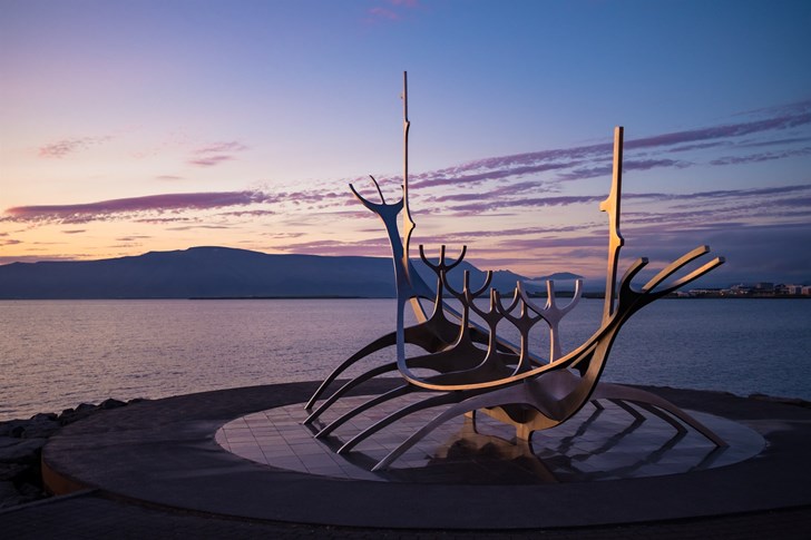 Sculpture on Reykjavik seafront with the summer sun setting overhead.